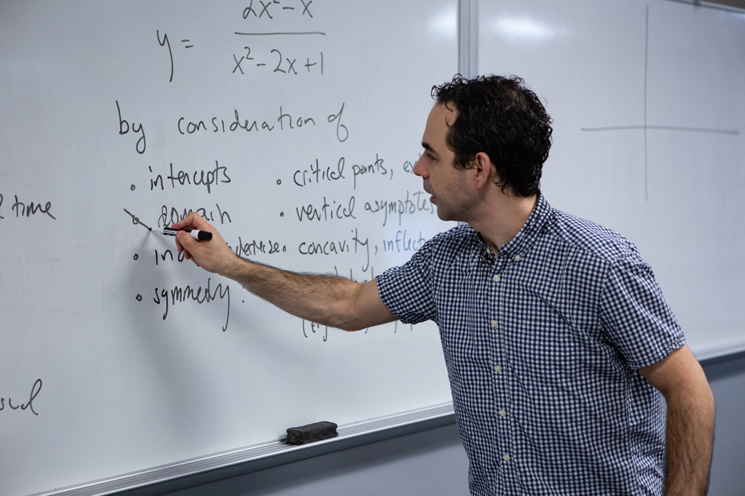 A math professor writes on a white board