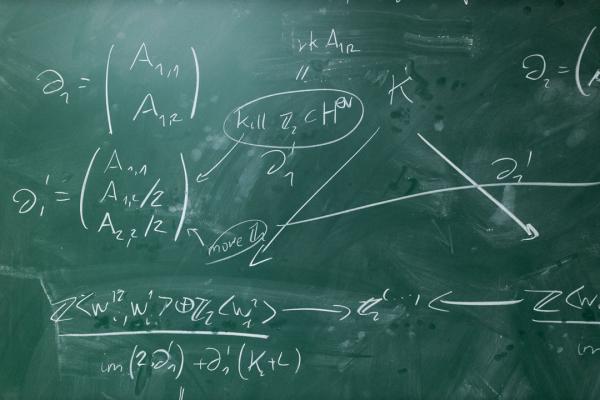 A green chalkboard covered in mathematical equations
