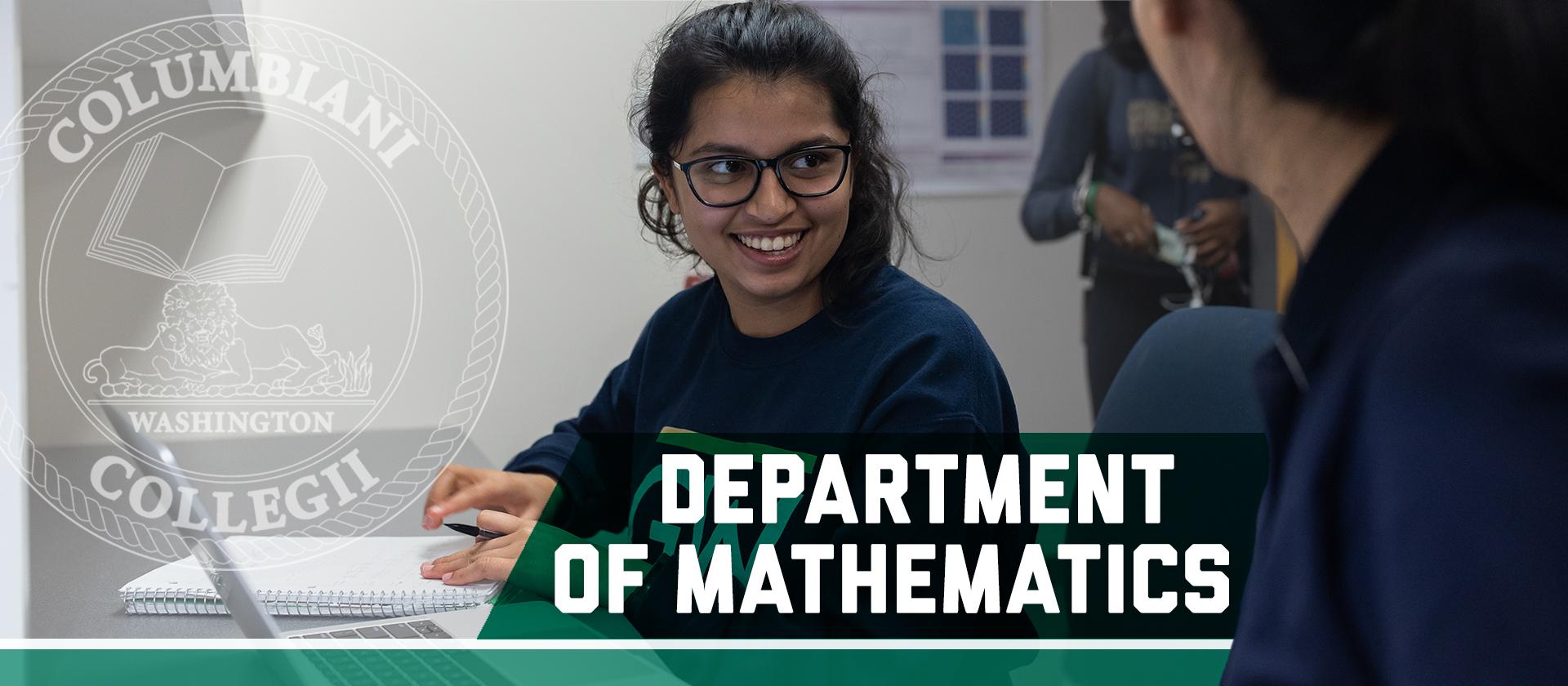 Two students working in a classroom. Department of Mathematics, Columbian College seal 